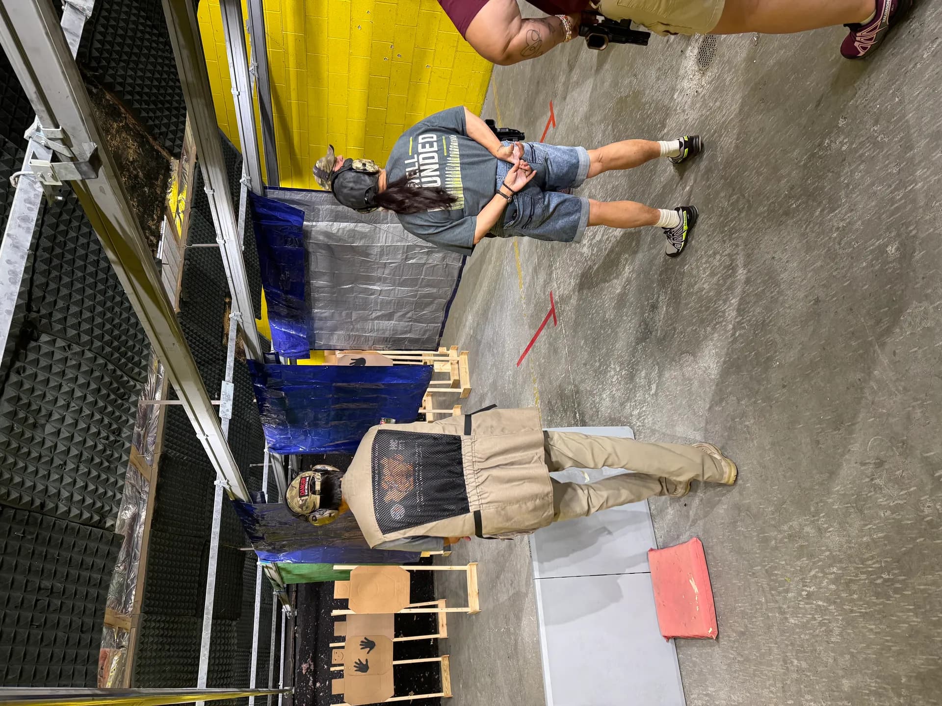 Two people coaching in an indoor range bay